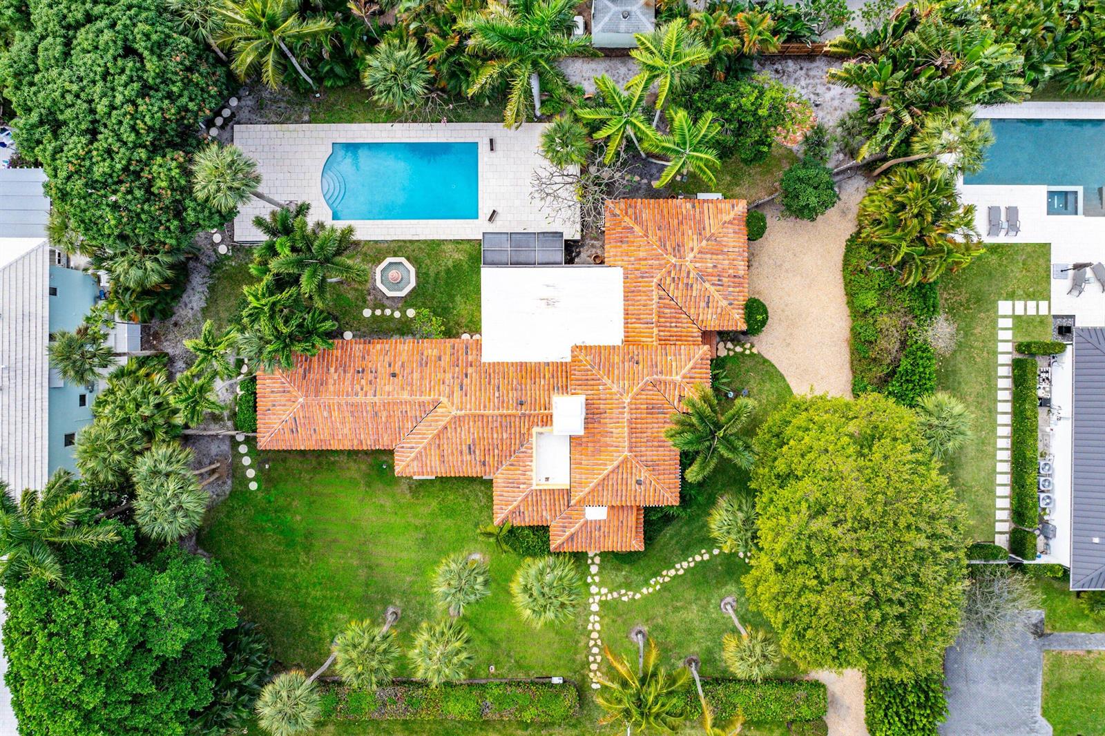 An aerial view shows a house with a terracotta roof, a pool, and lush landscaping — 334 Palm Trail, Delray Beach FL 33483, DELRAY BEACH, FL