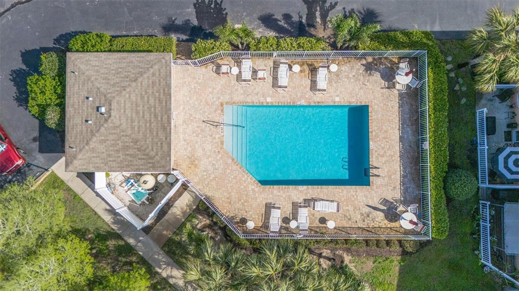 An aerial view of a rectangular swimming pool with a surrounding patio and lounge chairs — 1819 SOMMARIE WAY, TARPON SPRINGS, FL
