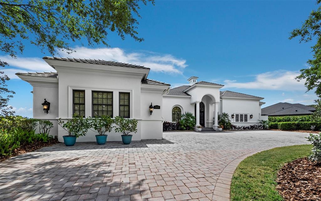 A white single-story house with a paved driveway and a covered arched entryway — 3129 FOUNDERS CLUB DRIVE, SARASOTA, FL