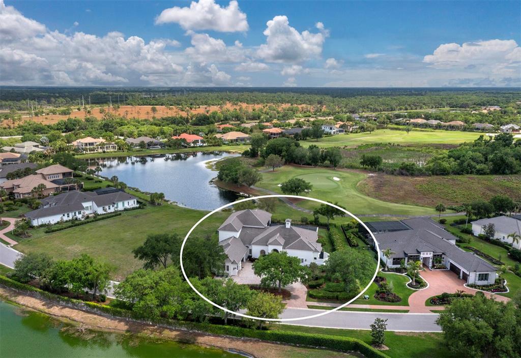 An aerial view shows a white house with a multi-gabled roof near a golf course — 3129 FOUNDERS CLUB DRIVE, SARASOTA, FL