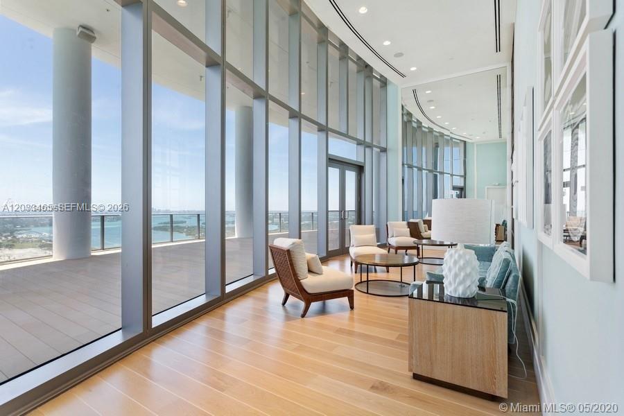 A bright living area features floor-to-ceiling windows, light wood flooring, and a view of water — 15701 E COLLINS # 1403, Sunny Isles Beach FL 33160, SUNNY ISLES BEACH, FL