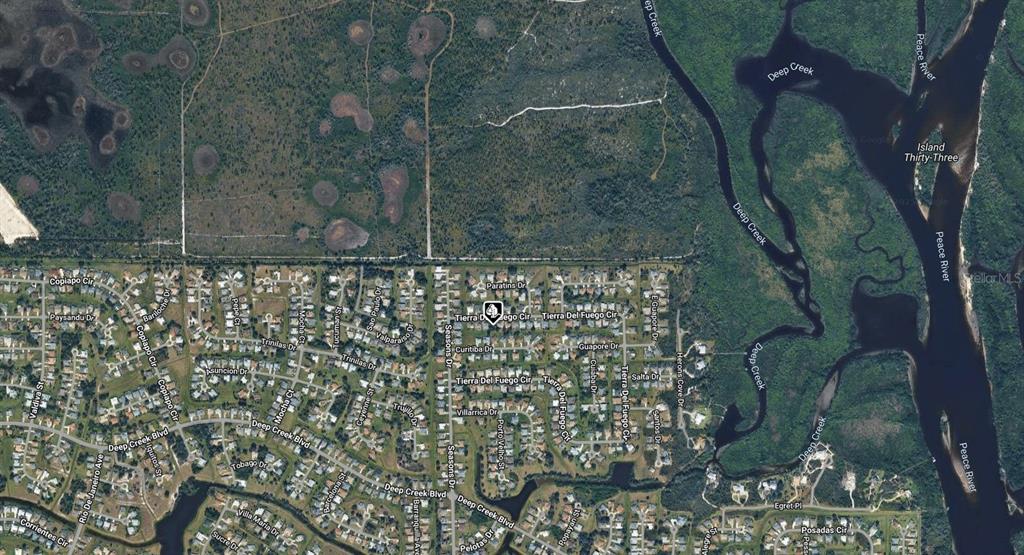 This is an aerial map view of a residential neighborhood bordering a river and forest — 27069 TIERRA DEL FUEGO CIRCLE, PUNTA GORDA, FL