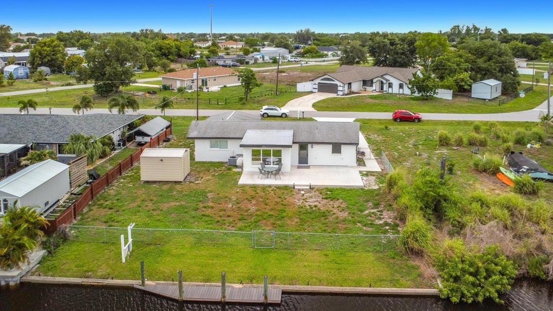 An aerial view of a single-story house with a backyard, patio, and private canal dock — 3234 Daytona Drive, Punta Gorda FL 33983, PUNTA GORDA, FL