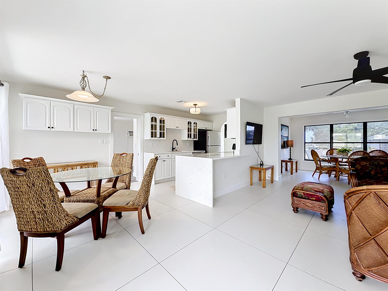 An open-concept kitchen and dining area features white cabinetry, quartz countertops, and tile flooring — 3234 Daytona Drive, Punta Gorda FL 33983, PUNTA GORDA, FL