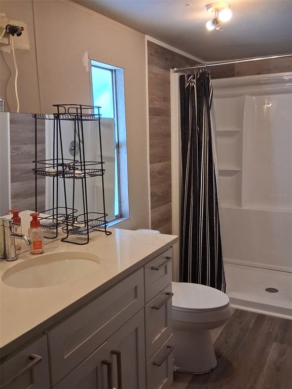 A bathroom features a vanity with a white countertop, a toilet, and a shower stall — 1804 DOROTHY BOULEVARD UNIT 403, LUTZ, FL