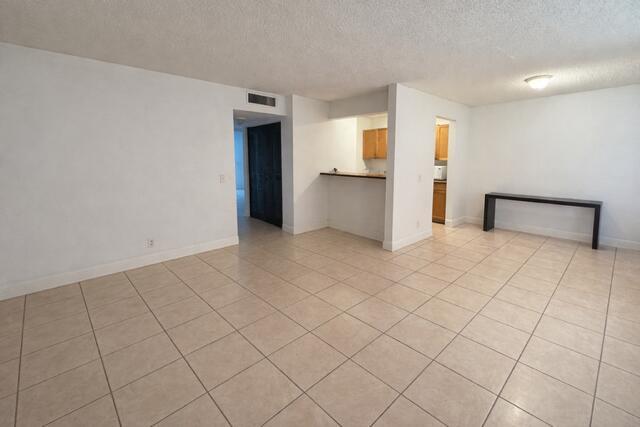 An open-concept living area features light-colored tile flooring and a kitchen pass-through counter — 416 Meadows Circle, Boynton Beach FL 33436, BOYNTON BEACH, FL