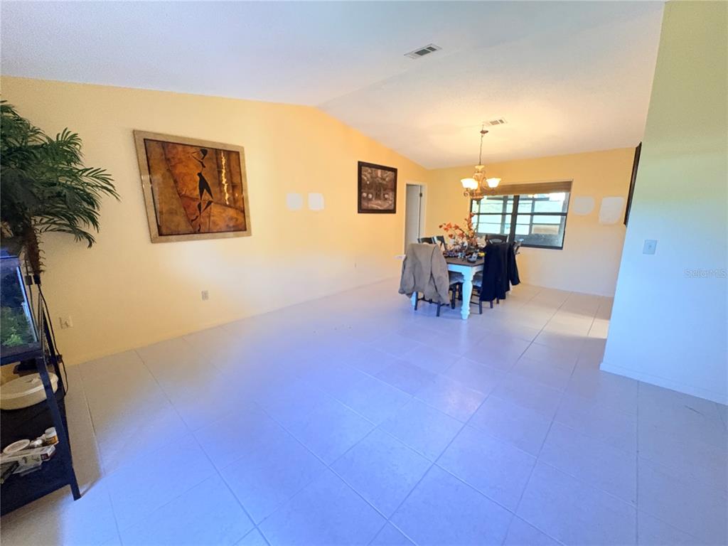 A dining area with tile flooring, yellow walls, and a chandelier over a table — 12 WESTGABLE PLACE, PALM COAST, FL
