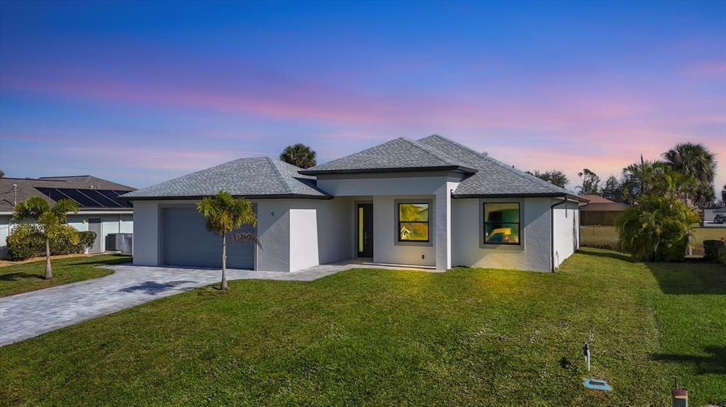 A single-story white house with a gray shingled roof and a paved driveway — 9 BUNKER PLACE, ROTONDA WEST, FL