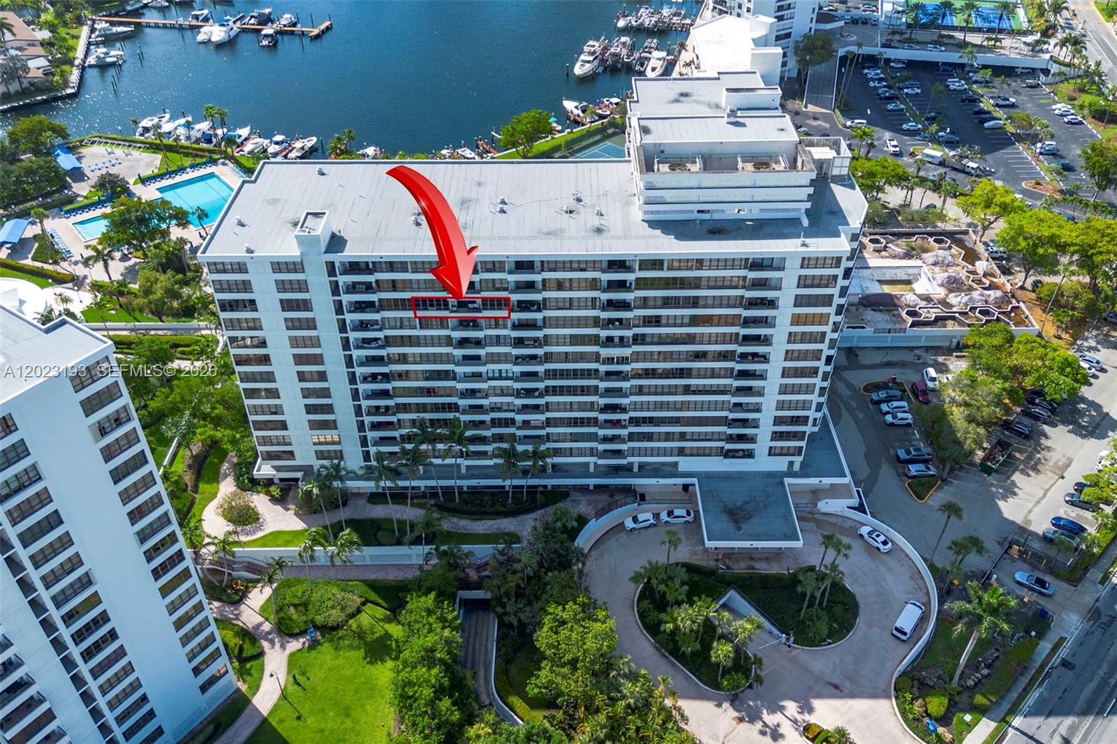 An aerial view shows a multi-story residential building with a red arrow highlighting a balcony — 500 Three Islands Blvd # 1008, Hallandale Beach FL 33009, HALLANDALE BEACH, FL