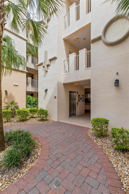 A paved walkway leads to an elevator entrance at the base of a multi-story building — 35 RIVERVIEW BEND S UNIT 1841, PALM COAST, FL