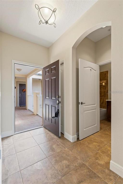 An entryway with tan tile flooring, a dark brown front door, and an arched doorway — 35 RIVERVIEW BEND S UNIT 1841, PALM COAST, FL