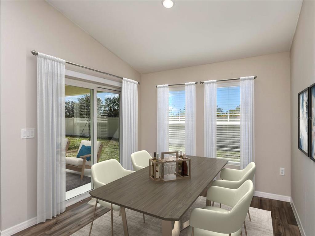 A dining room with a wooden table, white chairs, sliding glass doors, and large windows — 4429 RIVERBEND BOULEVARD, HAINES CITY, FL