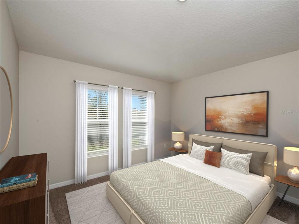 A bedroom features a bed with patterned bedding, two windows with white curtains, and artwork — 4429 RIVERBEND BOULEVARD, HAINES CITY, FL