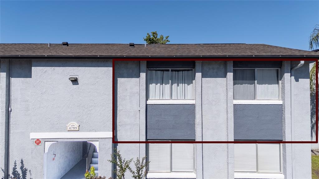 An exterior view of a two-story apartment building with a highlighted upper-level unit — 4789 S TEXAS AVENUE UNIT 4789D, ORLANDO, FL