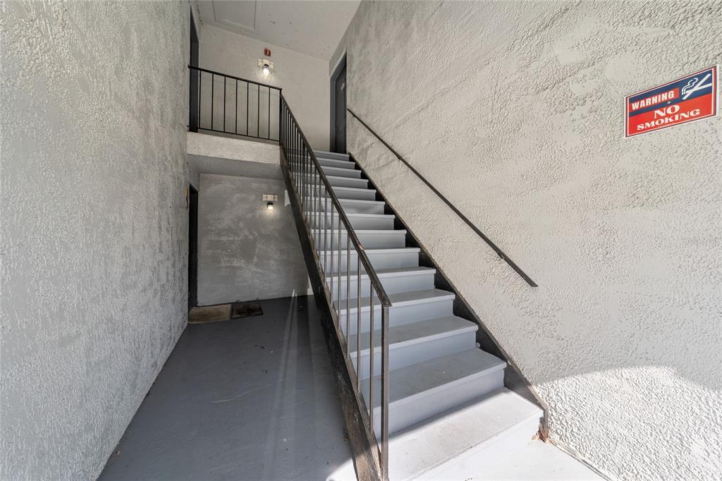 An outdoor staircase with metal railings leads to an upper-level landing at an apartment building — 4789 S TEXAS AVENUE UNIT 4789D, ORLANDO, FL