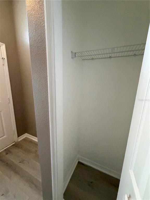 A small closet with a wire shelf and light-colored wood-look flooring — 5539 SYCAMORE CANYON DRIVE, KISSIMMEE, FL