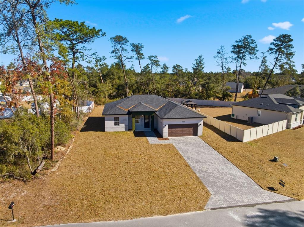 An aerial view of a single-story house with a paved driveway and a fenced yard — 4473 SW 168TH LANE, OCALA, FL