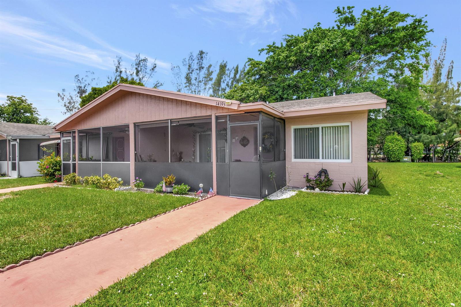 A single-story house with a screened-in front porch and a pink exterior sits on grass — 14195 Campanelli Drive, Delray Beach FL 33484, DELRAY BEACH, FL