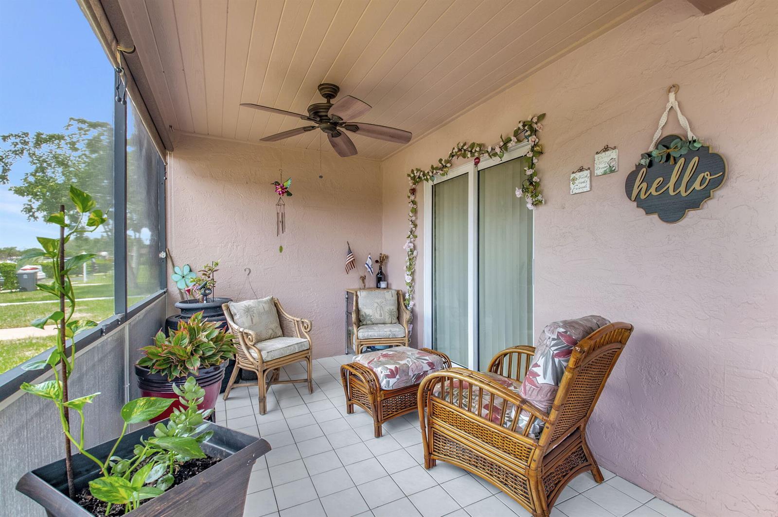 A screened-in patio features wicker furniture, a ceiling fan, and light pink stucco walls — 14195 Campanelli Drive, Delray Beach FL 33484, DELRAY BEACH, FL