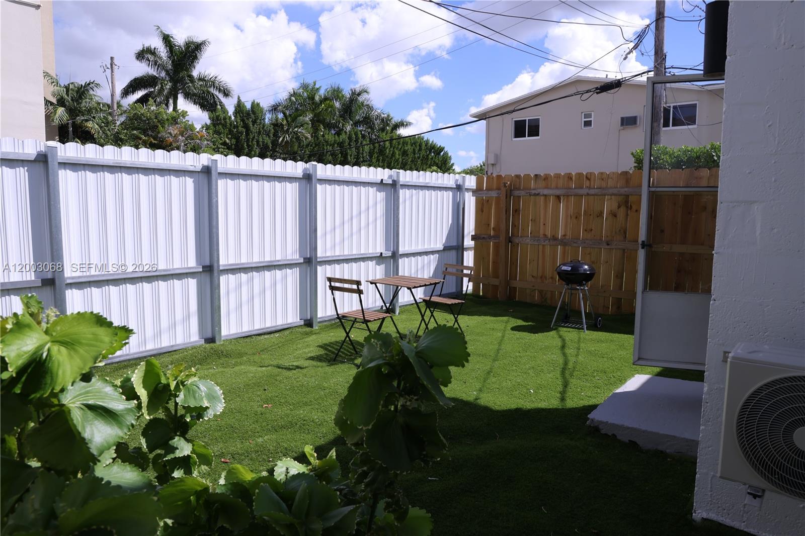 A small backyard features artificial turf, a white metal fence, and a wooden privacy fence — 1109 SW 37th Ave # 1115, Miami FL 33135, MIAMI, FL