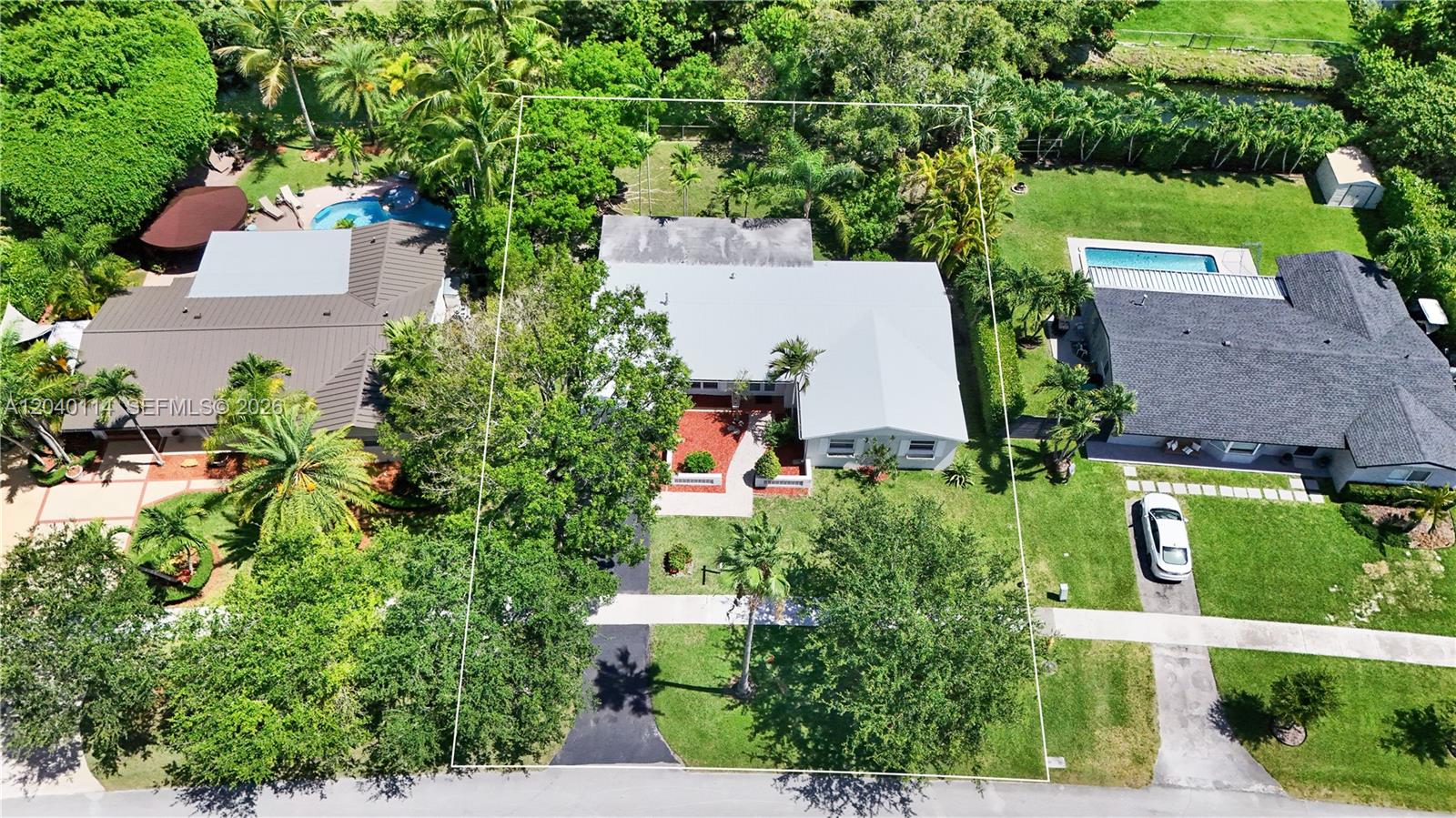 An aerial view shows a single-story house with a metal roof and a paved driveway — 10435 SW 96th St, Miami FL 33176, MIAMI, FL