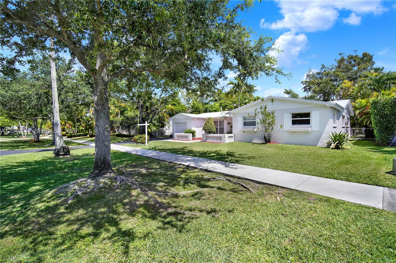 A single-story house with a light-colored exterior sits behind a lawn and sidewalk — 10435 SW 96th St, Miami FL 33176, MIAMI, FL