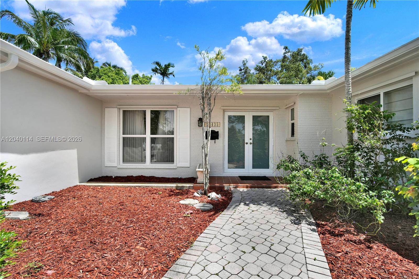 A white brick house exterior features a paved walkway, double front doors, and red mulch — 10435 SW 96th St, Miami FL 33176, MIAMI, FL