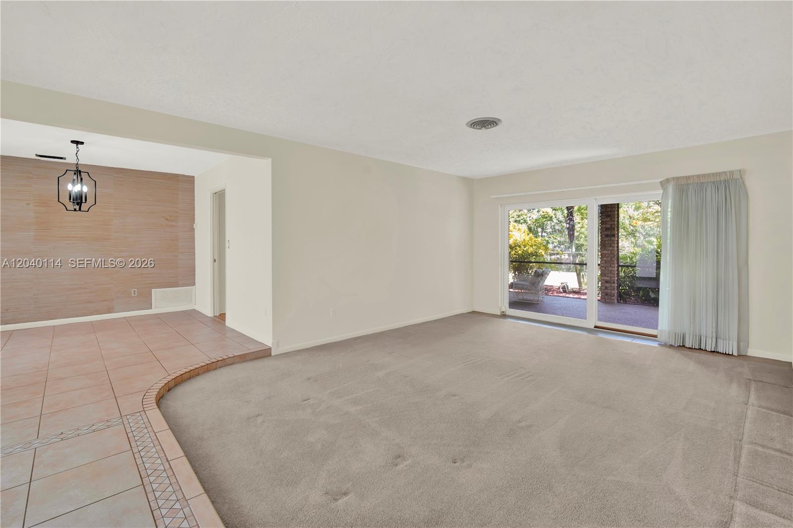 A living room features a carpeted sunken floor, tile entryway, and sliding glass patio doors — 10435 SW 96th St, Miami FL 33176, MIAMI, FL