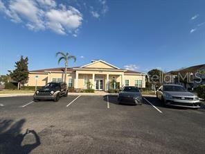 A single-story building with a beige exterior and a parking lot in front — 8962 SILVER PLACE, KISSIMMEE, FL