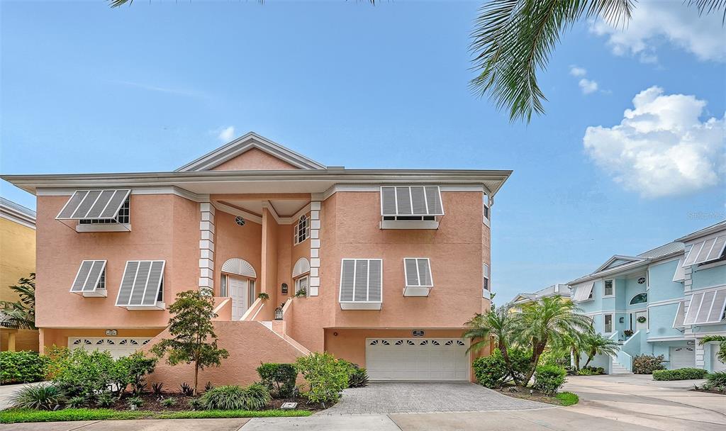 A two-story peach-colored house with a white garage and metal window awnings — 3942 HAMILTON CLUB CIRCLE UNIT 13, SARASOTA, FL