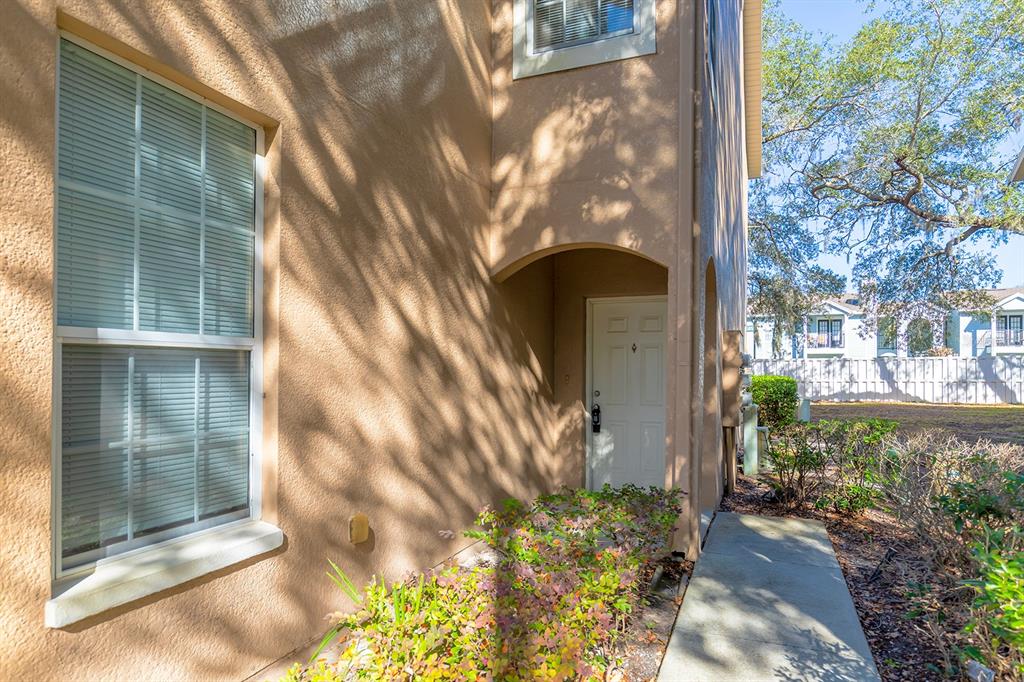 A tan stucco exterior features a recessed front door, a large window, and a walkway — 2536 LANCIEN COURT UNIT 5, ORLANDO, FL