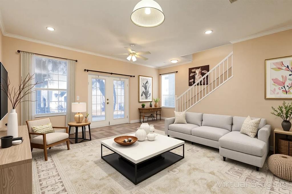 This living room features a sectional sofa, coffee table, armchair, and staircase with white railings — 2536 LANCIEN COURT UNIT 5, ORLANDO, FL