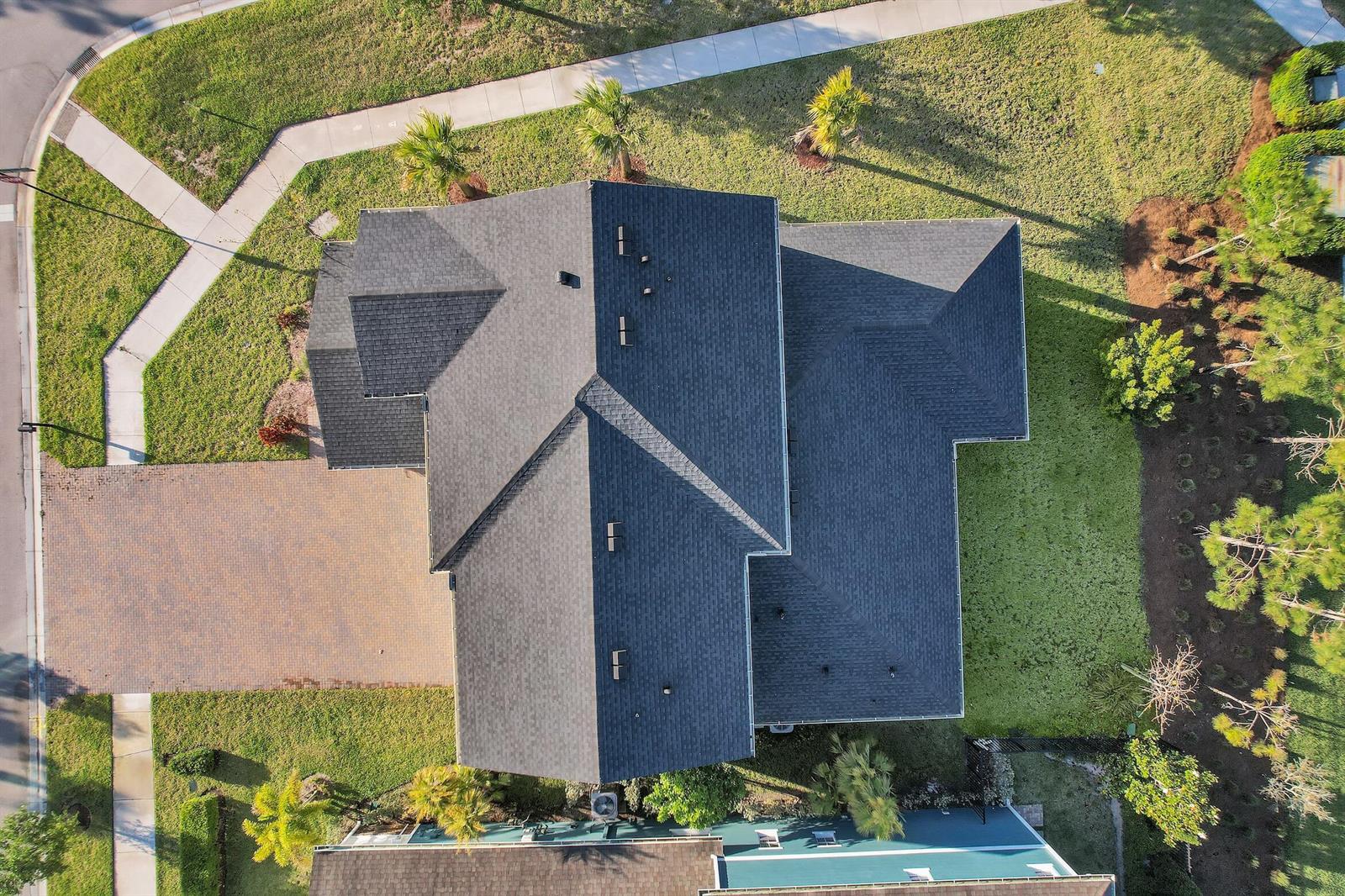 An aerial view shows the dark shingled roof of a house with a paved driveway — 1168 Sterling Pine Place, Loxahatchee FL 33470, LOXAHATCHEE, FL