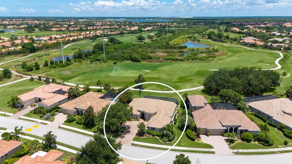 An aerial view shows a single-story house with a tiled roof and a screened pool — 225 PESARO DRIVE, NORTH VENICE, FL