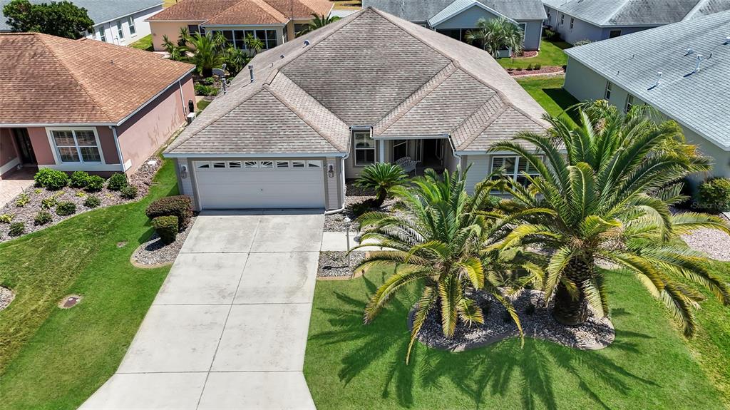An aerial view of a suburban house with a two-car garage and palm trees — 934 MOSES LOOP, THE VILLAGES, FL