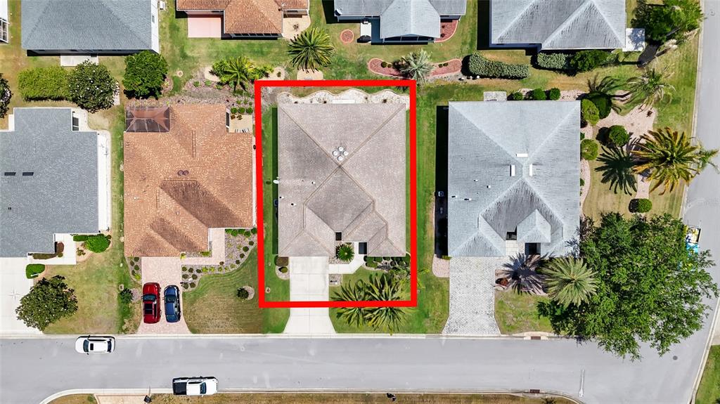 An aerial view shows a single-family home with a gray roof and a concrete driveway — 934 MOSES LOOP, THE VILLAGES, FL