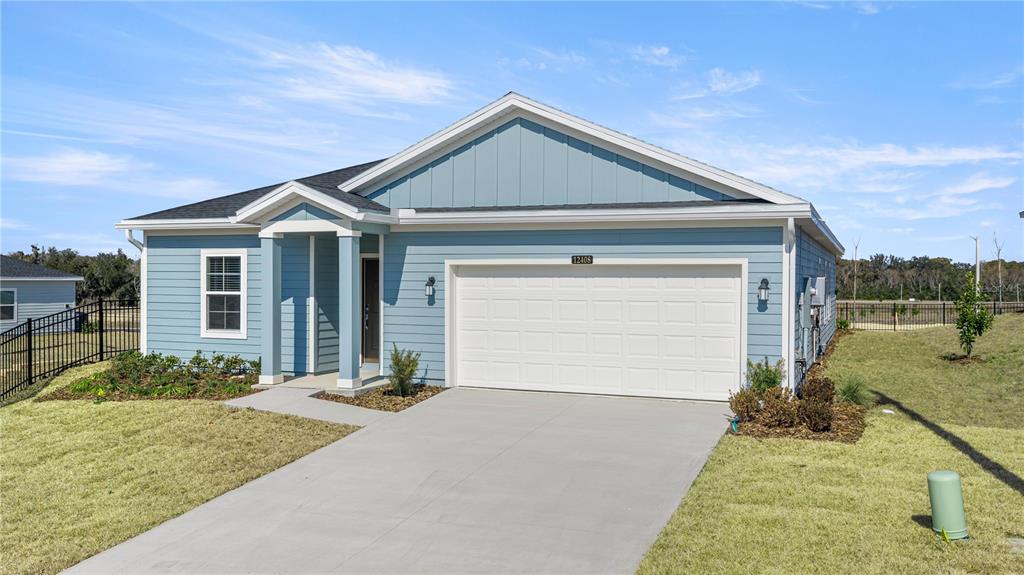 A single-story blue house with a white garage door and a covered front entryway — 8814 SW 69TH TERRACE, OCALA, FL