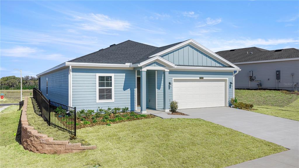 A light blue single-story house with a white garage door and a black metal fence — 8814 SW 69TH TERRACE, OCALA, FL