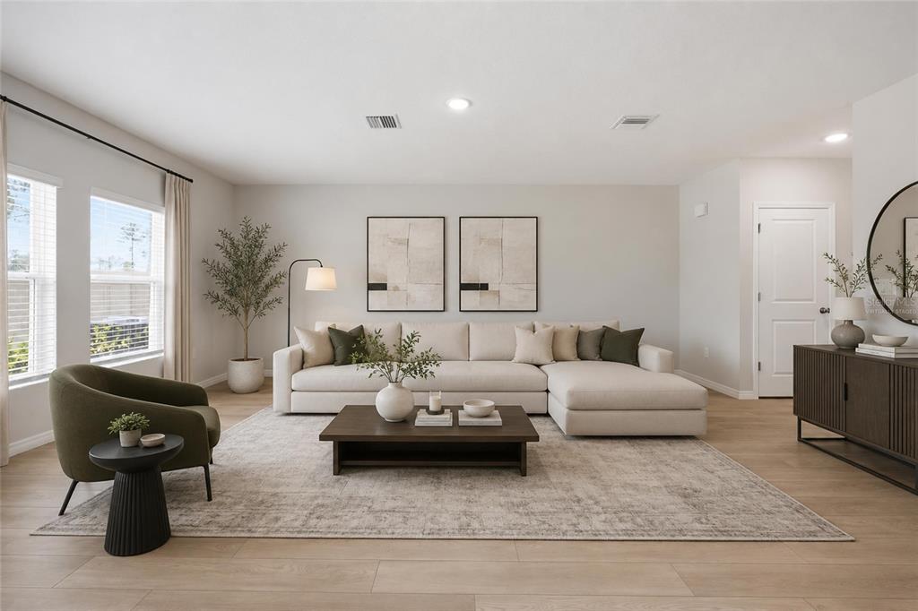 A living room features a beige sectional sofa, a coffee table, and an olive armchair — 37114 SAGEMOOR DRIVE, ZEPHYRHILLS, FL
