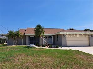 A single-story house with a tan exterior, a two-car garage, and palm trees in front — 26 CLINTWOOD AVENUE, ENGLEWOOD, FL