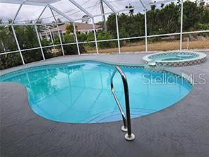 A swimming pool and attached hot tub are enclosed within a screened-in patio area — 26 CLINTWOOD AVENUE, ENGLEWOOD, FL