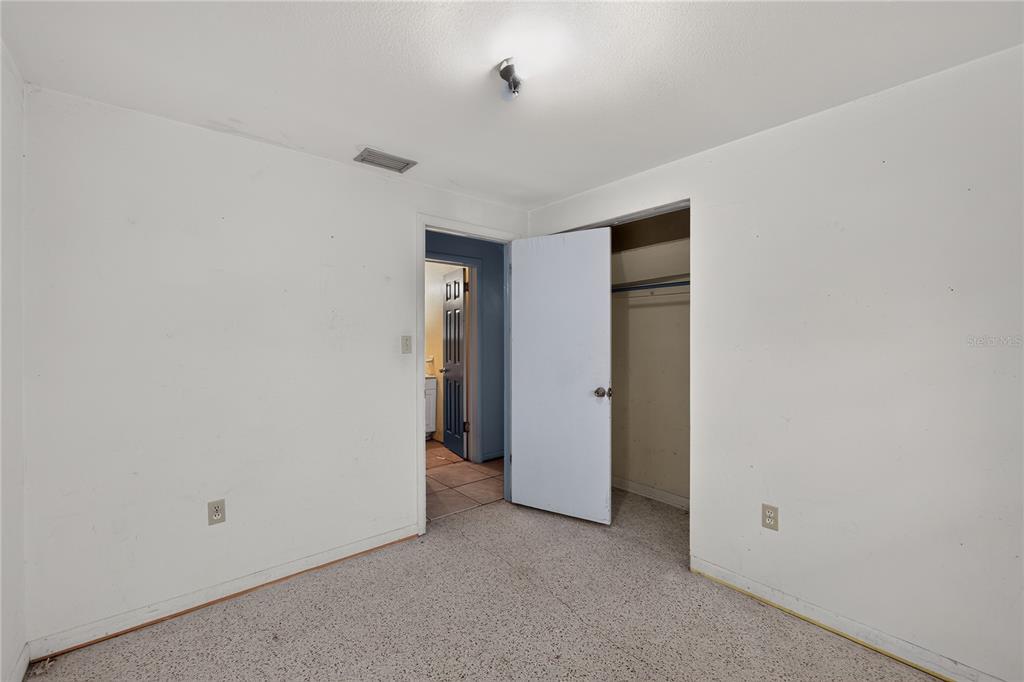 A bedroom with white walls, carpeted flooring, a closet, and a doorway leading to a bathroom — 4315 E COUNTY ROAD 540A, LAKELAND, FL