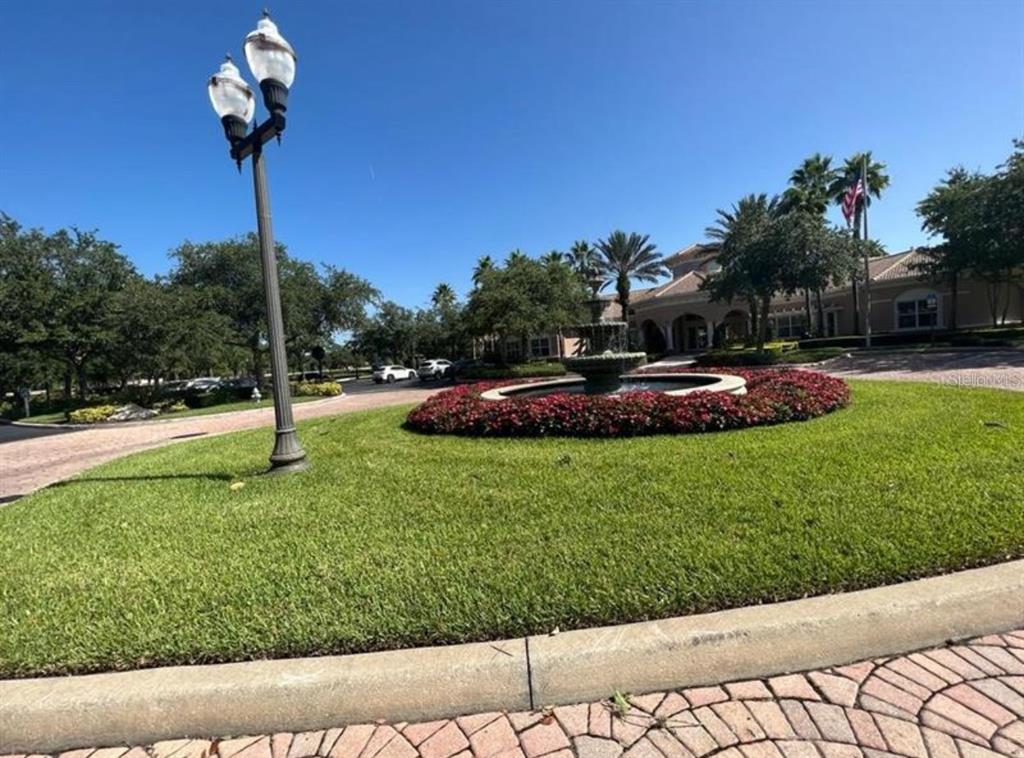 A circular fountain sits in the center of a landscaped lawn in front of a building — 1357 VENEZIA COURT UNIT 102, DAVENPORT, FL