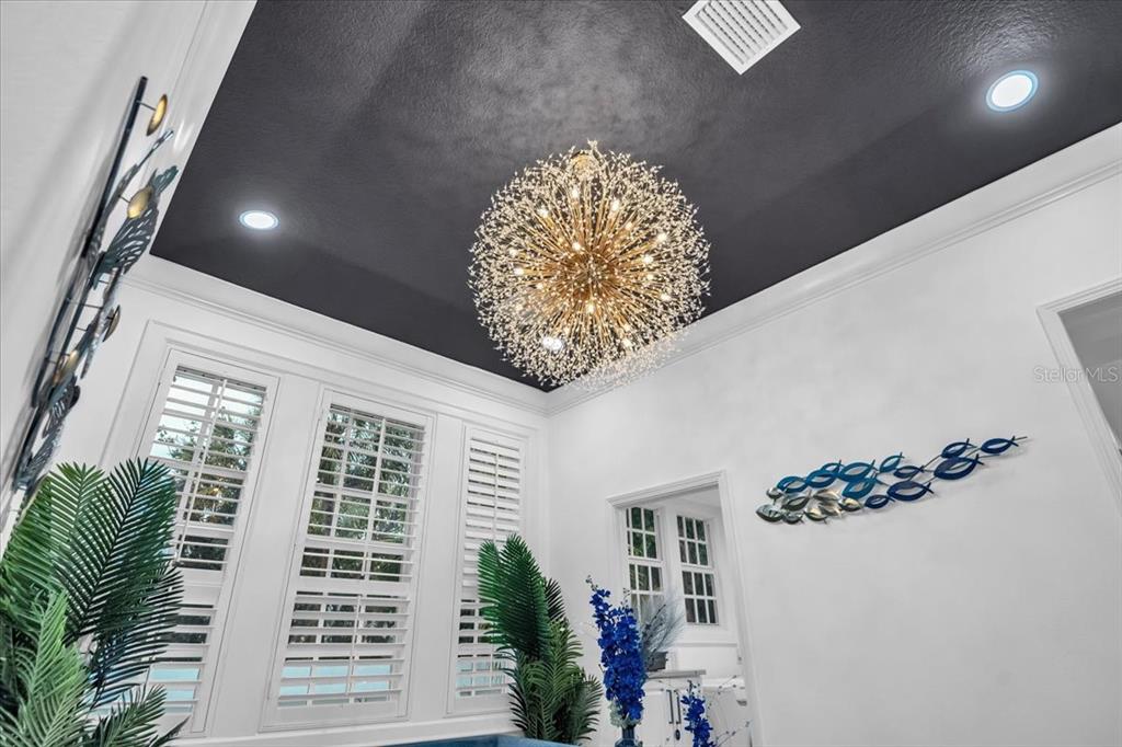 A room with white walls, a dark tray ceiling, and a large starburst chandelier — 115 EDMONDSON AVENUE, SARASOTA, FL