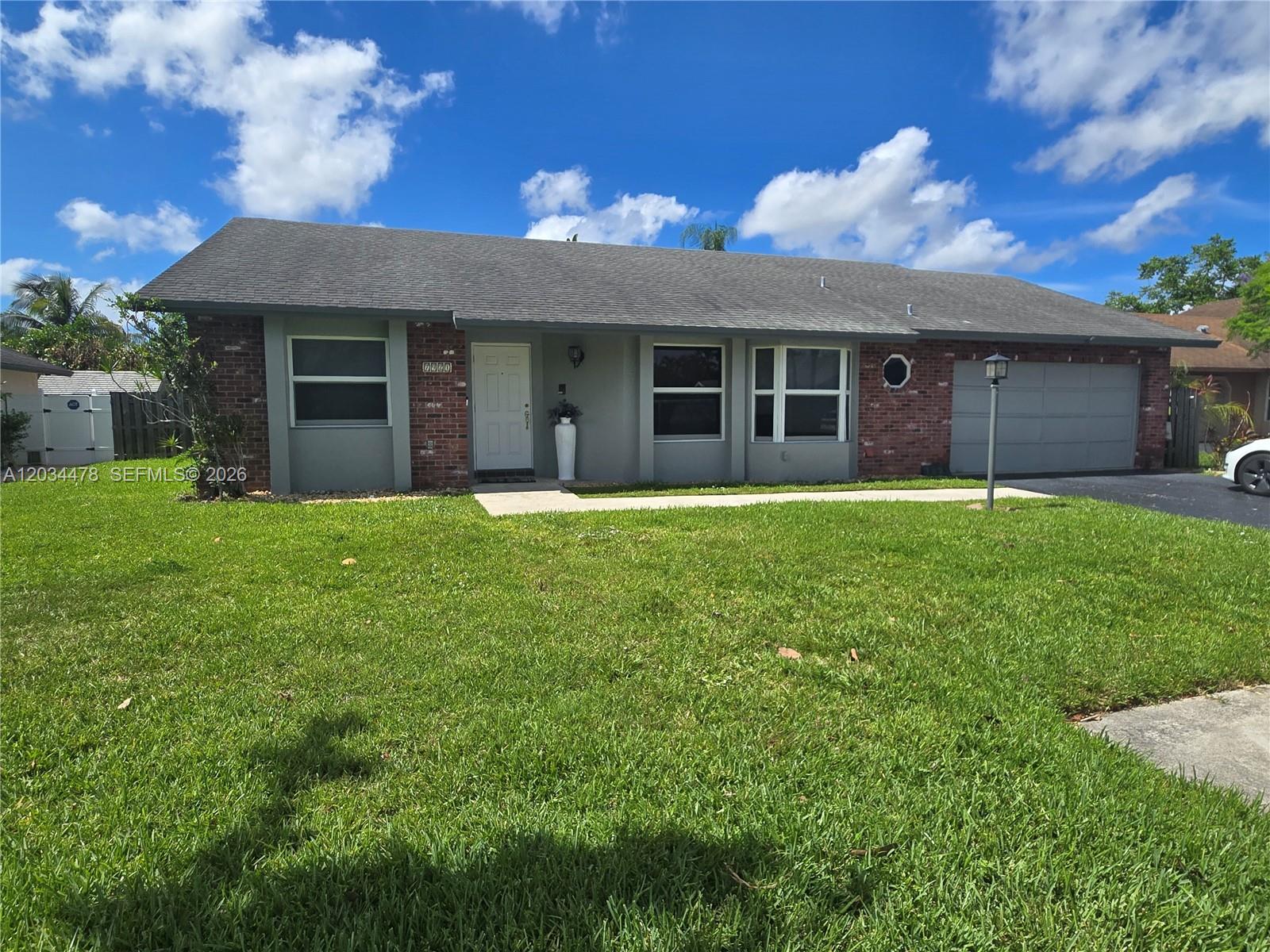 A single-story house with a brick and gray facade, a front door, and a garage — 7921 NW 4th St, Plantation FL 33324, PLANTATION, FL
