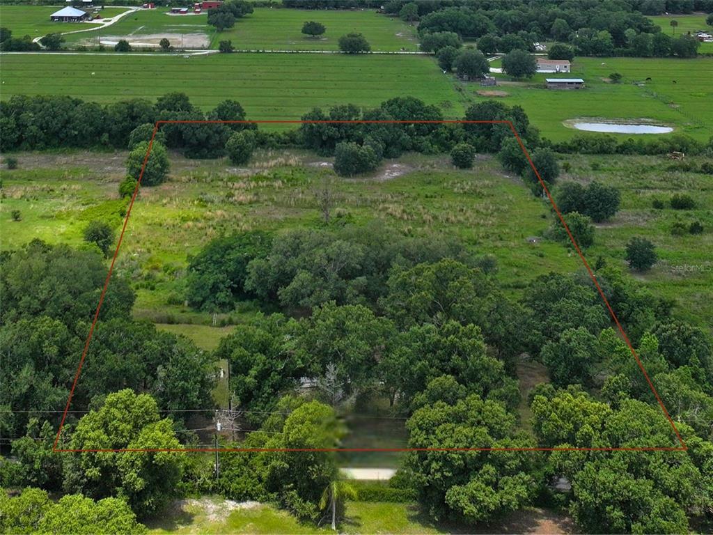 An aerial view shows a large, rectangular plot of land outlined in red — 9827 SE HOTH ROAD, ARCADIA, FL