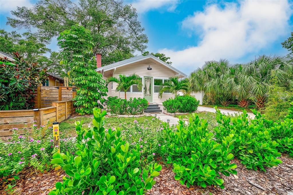 A single-story house with light siding, a gabled roof, and a landscaped front yard — 440 22ND STREET N, ST PETERSBURG, FL