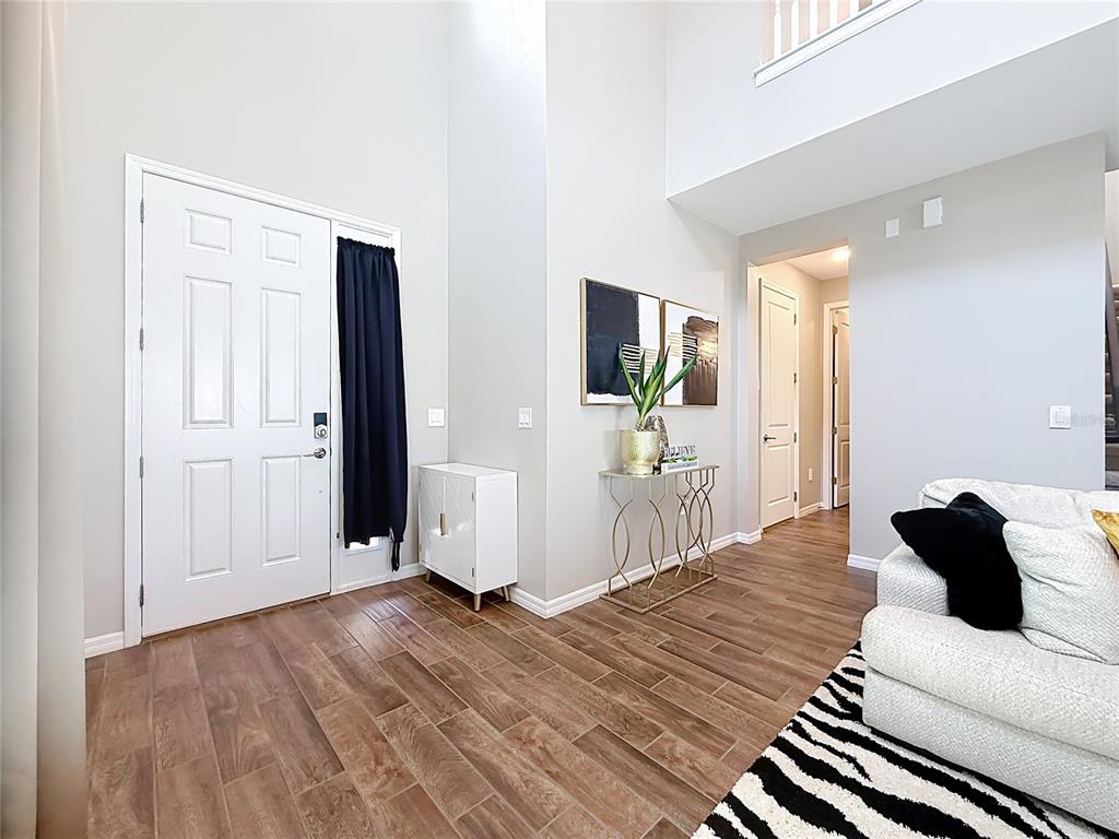 An entryway with wood-look tile flooring, a white door, and a console table — 2854 HIGH POINTE STREET, CLERMONT, FL