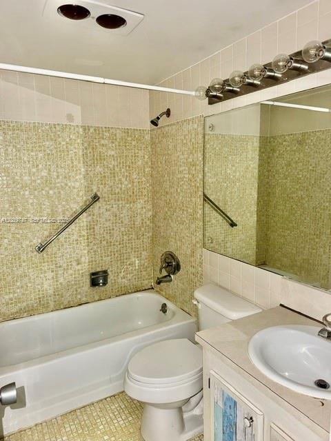 A bathroom features a tiled tub surround, a toilet, and a vanity with a sink — 119 Salisbury, West Palm Beach FL 33417, WEST PALM BEACH, FL