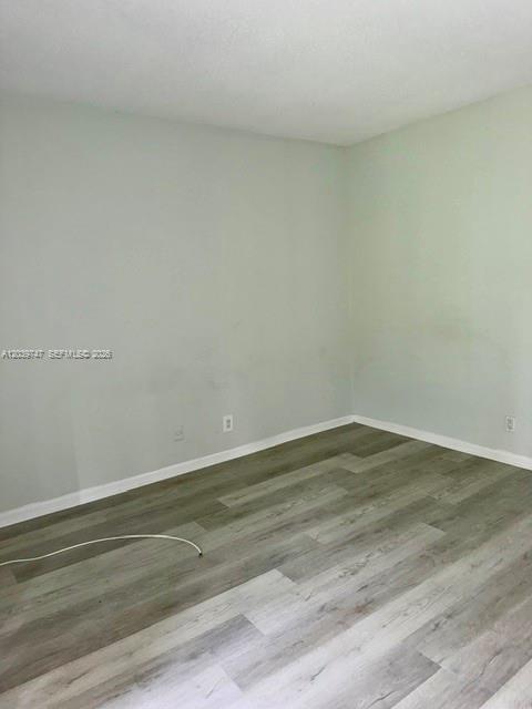 An empty room features light-colored walls and wood-look laminate flooring — 119 Salisbury, West Palm Beach FL 33417, WEST PALM BEACH, FL